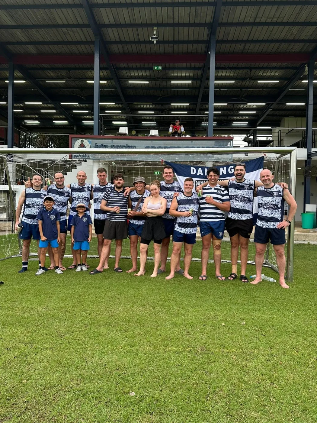 Club members and their families in hooped shirts lined up on the grass