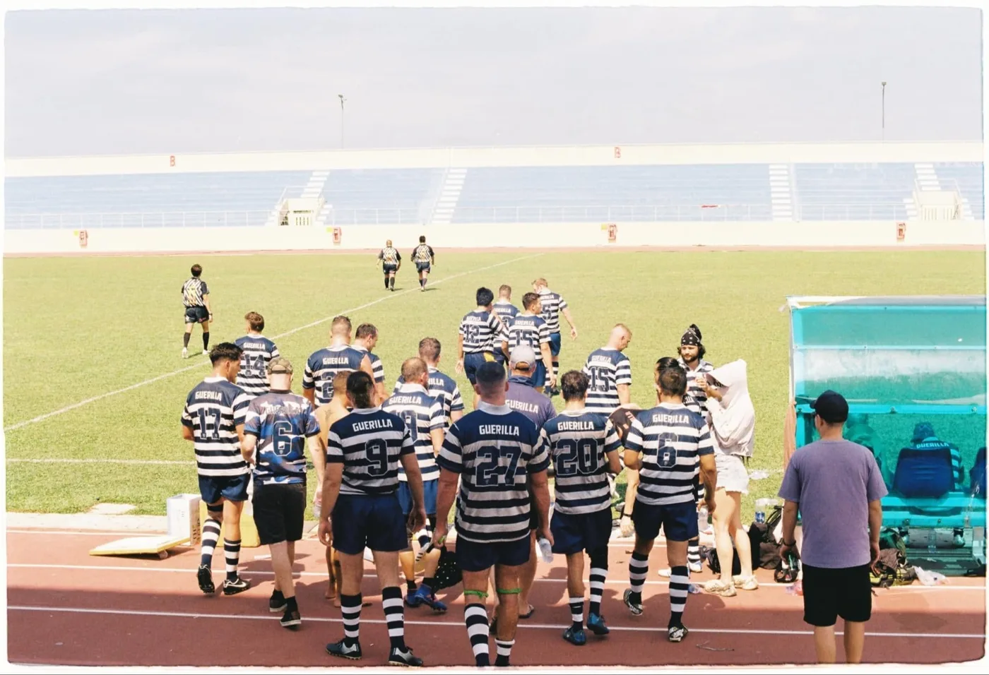 The team in hooped shirts walking out onto a stadium pitch